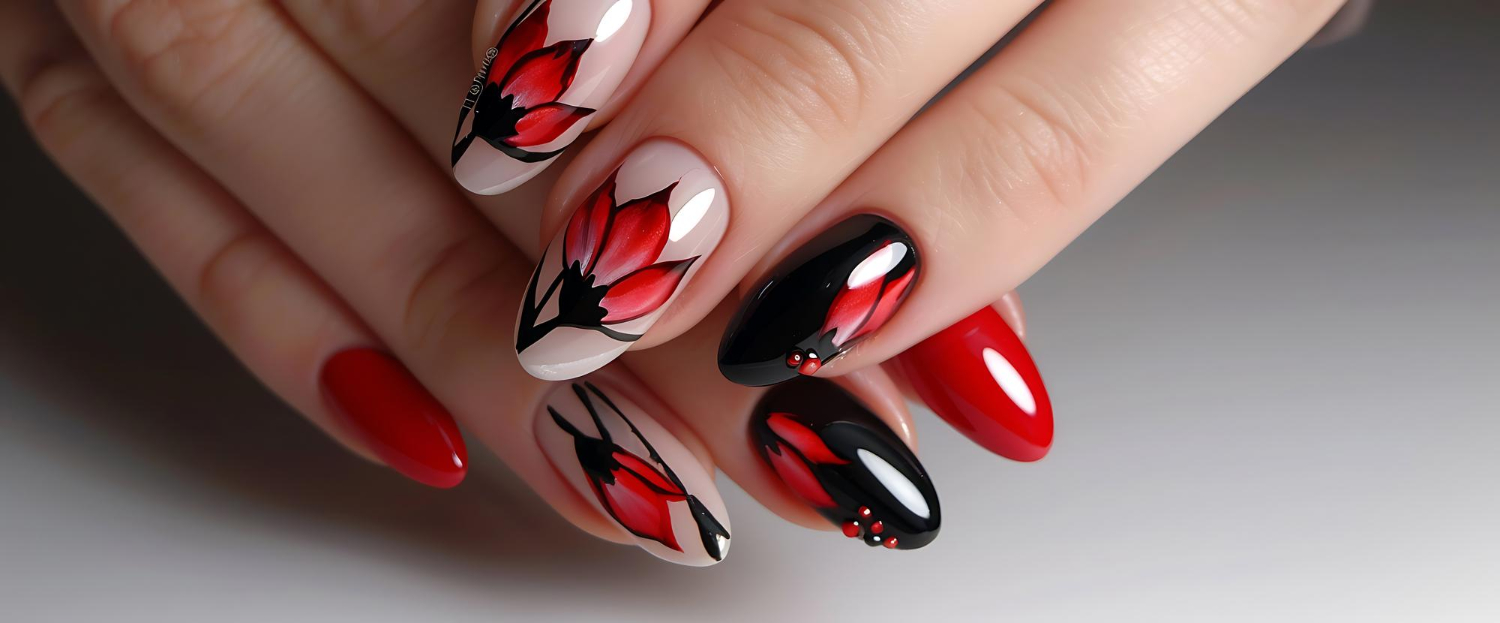 Vue rapprochée d'une main avec des ongles rouge et noir avec des fleurs 